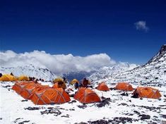 tents pitched up in the snow with mountains in the background