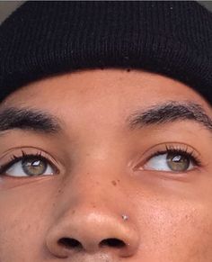 a close up of a person wearing a beanie and looking to the side with his eyes wide open