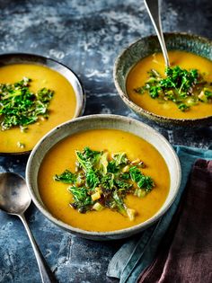 two bowls of soup with broccoli and other vegetables on the side, one bowl is filled with soup