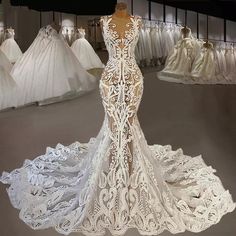 a white wedding dress on display in a bridal room with gowns behind it