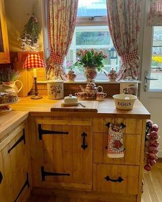 the kitchen is decorated in pink and white checkered curtains, potted plants on the window sill