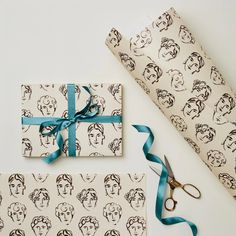 two wrapping paper wrapped in blue ribbon and scissors