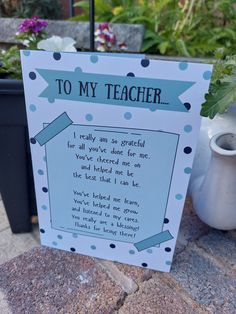 a card that says to my teacher on the side of a table next to potted plants