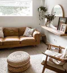 a living room filled with furniture and a large mirror on the wall above it's windows