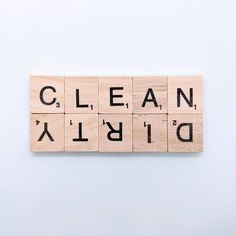 scrabbled wooden blocks spelling the word clean and dirty on a white background