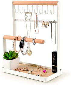 a jewelry rack with several necklaces and a potted plant on top of it