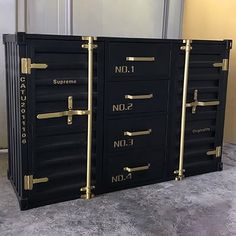 three black drawers with gold handles and numbers on them in front of a door that says supreme no 1, no 2, no 3