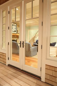 the inside of a house with wooden floors and glass doors