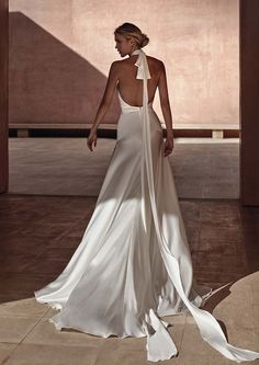 a woman in a white dress standing on a tile floor with her back to the camera