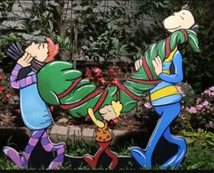 two cartoon figures are in the grass near some bushes and flowers, one is holding onto another figure