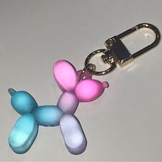 a keychain shaped like a poodle with pink, blue and green colors