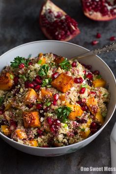 a white bowl filled with food next to two pomegranates