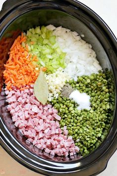 the ingredients for this meal are mixed together in a crock pot, including onions, carrots, and green beans