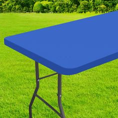 a blue table sitting on top of a lush green field