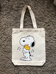 a white bag with a cartoon character holding a sunflower in it's mouth