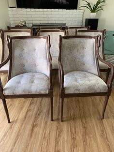 four chairs sitting in front of a fireplace with a tv on the wall behind them