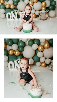 a baby sitting on top of a cake in front of some green and white balloons