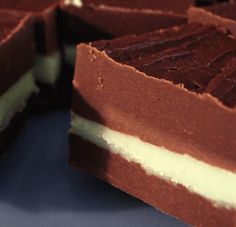 several pieces of chocolate cake sitting on top of a blue plate with one slice cut out