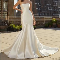 a woman in a white wedding dress standing on a rooftop