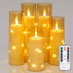 there are many lit candles with remotes next to them