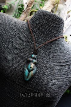 a necklace with two blue beads hanging from it's back on a mannequin