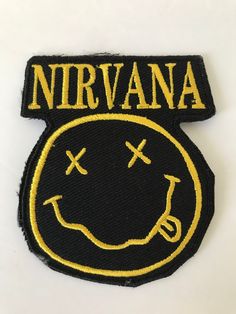 a black and yellow embroidered patch with the words nirvana on it's back side