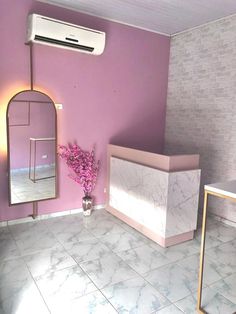 a bathroom with pink walls and white tile flooring is pictured in this image, there is a mirror on the wall next to the sink