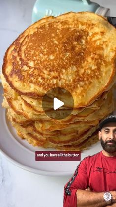 a man standing in front of a stack of pancakes