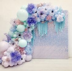 the balloon arch is decorated with pastel blue, pink and purple flowers on it