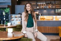 a woman sitting at a table in a restaurant with her legs crossed on the counter