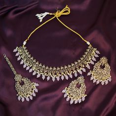 Immerse yourself in the enchanting world of elegance with our Baby Pink Handmade Punjabi Jewelry Set. This exquisite ensemble, inspired by the rich traditions of Indian Bollywood fashion, is a testament to fine craftsmanship and timeless beauty. Perfect for weddings, parties, and engagement celebrations, this high-quality jewelry set is designed to make you stand out on your special day. The necklace, earrings, and tikka in this set are meticulously handmade, showcasing the skillful artistry tha Pink Necklaces With Matching Earrings For Wedding, Pink Wedding Necklaces With Matching Earrings, Elegant Pink Gift Sets, Elegant Stone Work Sets For Gift, Pink Bridal Necklace With Matching Earrings For Wedding, Elegant Chandbali Sets With Matching Earrings, Elegant Bridal Accessories With Stone Work For Party, Wedding Jewelry Set With Matching Earrings, Elegant Party Bridal Accessories With Stone Work