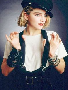 a woman wearing a police hat and black leather gloves with her hands in the air