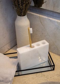 a toothbrush holder sitting on top of a marble counter