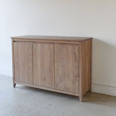 a wooden cabinet sitting against a white wall