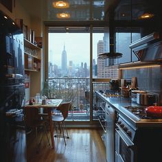 a kitchen with a table and chairs in front of a large window overlooking the city