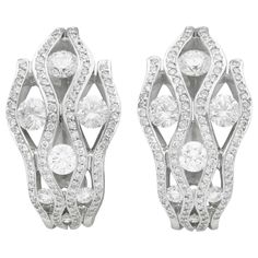 A stunning, fine and impressive pair of 2.94 carat diamond and 18 karat white gold earrings; part of our diverse vintage jewelry and estate jewelry collections. These stunning, fine and impressive vintage diamond earrings have been crafted in 18k white gold. Each earring features four vertical opposing undulating pales, ornamented with one-hundred-and-two pavé set modern brilliant round cut diamonds. Each earring is ornamented with seven modern brilliant round cut diamonds, graduating in size dependant on location. These impressive vintage earrings for pierced ears secure to the reverse with a post and hinged latch style fastening. These earrings are hallmarked to the outer surface of the hinged latch with the monogrammed maker's signature. The earrings have been independently tested using Vintage Diamond Earrings, Diamond Earrings For Women, Wedding Jewelry Earrings, White Gold Earrings, Vintage Diamond, Vintage Jewellery, Round Cut Diamond, Wedding Earrings, Estate Jewelry