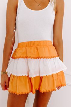 - Step up your pep with this adorable mini skirt! Its playful rick rack trim adds a trendy touch to your game day look to ensure you stand out from the crowd. Perfect for game day or anytime you want to add a pop of team spirit, this piece was made to keep you looking stylish. Get the Game Day essentials for the University of Tennessee Volunteers, or the University of Texas Longhorns teams. - Unlined material - Rick rack accent trim - A wide elastic banded waist - A flattering tiered silhouette Orange Bottoms, Tn Vols Gameday Outfit Women, Okstate Game Day Outfit, Orange Western Outfit, Cute Orange Outfit, Ut Gameday Outfit Tennessee, Ut Gameday Outfit, Ut Vols Gameday Outfit, Tennessee Vols Game Day Outfits