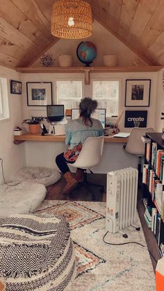 a person sitting at a desk in a room with lots of books on the shelves