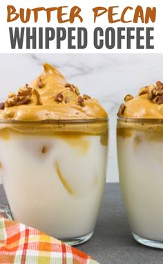 two glasses filled with whipped coffee on top of a table