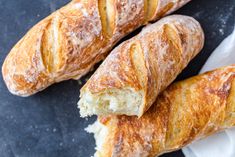 three croissants sitting on top of each other next to a piece of bread