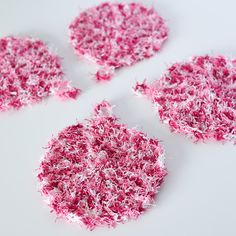 four pieces of pink and white shredded paper are arranged in the shape of an ornament