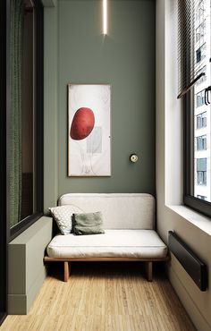 a white couch sitting next to a window on top of a hard wood floored floor