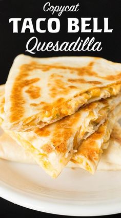 two quesadillas stacked on top of each other on a white plate against a black background