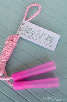 two pink jump ropes tied to each other with a sign that says free jump for joy it's summer time