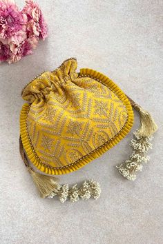 "Our Leela heritage potli is pure class and opulence. The beauty lies in heavy detailed handcrafted tassles that add the weight to this potli and will charm everyone off their feet! Colour: Yellow with goldembroidery Embroidered front and back. Dimensions (LxB): 8.5\"x 9.5\" (22 cm x 24 cm) Handle drop: 5\" (13 cm) Material : Embroidered poly silk, gold tissue, poly satin lining, woven gold thread drawstrings and woven thread handle, handcrafted tassels." Luxury Traditional Potli Bag With Handwork, Luxury Embroidered Gold Potli Bag, Luxury Embroidered Potli Bag For Celebration, Luxury Embroidered Potli Bag For Reception, Affordable Traditional Potli Bag For Festivals, Cheap Traditional Potli Bag, Affordable Embroidered Potli Bag For Parties, Luxury Festival Potli Pouch Bag, Luxury Handmade Elegant Potli Bag