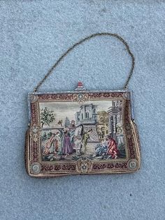 Antique Petit Point Tapestry Scenic Evening Handbag with Polished Carnelian Stone Lock  A lovely antique evening purse or bag with very fine hand embroidered petit point scenes on the front and back.  Each side is similar but depicts a different scene. The frame is engraved metal, and it fastens with a clever closure which is topped with a beautifully polished and shaped carnelian stone.  The inside is lined in silk and it has a small internal foldable wallet.  Purse measures approximately 7.25 inches long by 5.5 inches wide (not including height of stone lock).  Chain measures approximately 5.25 inches long (from top of extended chain to the top of the purse). In great condition for its age with no noticeable flaws. Please see all photos. Antique Embroidered Evening Bags, Vintage Embroidered Rectangular Evening Bag, Victorian Style Embroidered Rectangular Bag, Vintage Tapestry Handmade Bags, Vintage Handmade Tapestry Bag, Victorian Embroidered Evening Bags, Antique Tapestry Evening Bag, Vintage Tapestry Bags For Gifts, Vintage Embroidered Tapestry Shoulder Bag