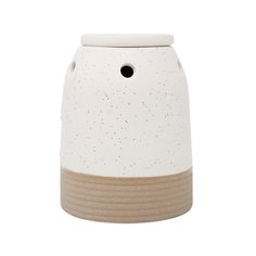 a white and brown ceramic vase with speckles on the bottom, sitting on a white surface