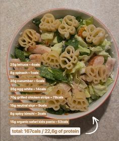 a bowl filled with pasta and vegetables on top of a table