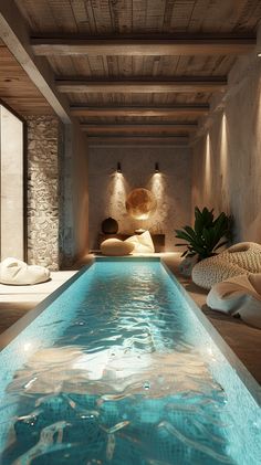 an indoor swimming pool surrounded by stone walls and flooring with lights on the ceiling