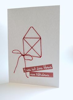 a greeting card with a red string wrapped around the envelope and an origami kite on it